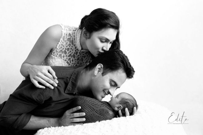 newborn with family portrait black and white Dad is holding newborn baby, mom is kissing him
