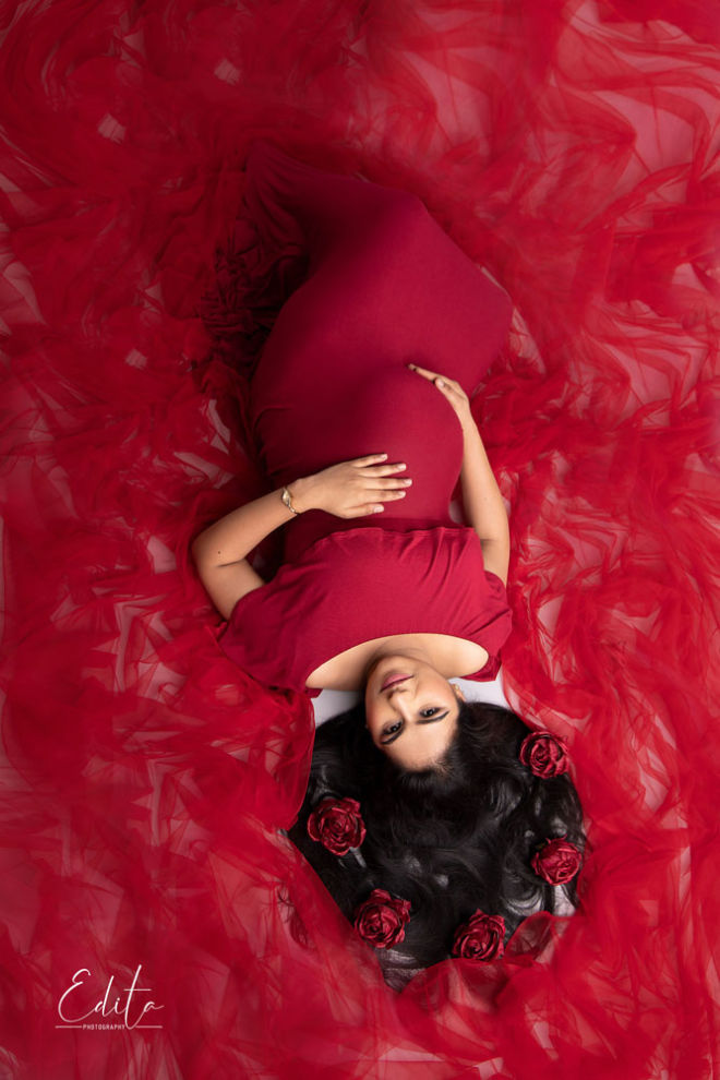 Maternity aerial photography in maroon gown with tulle spreaded aroung