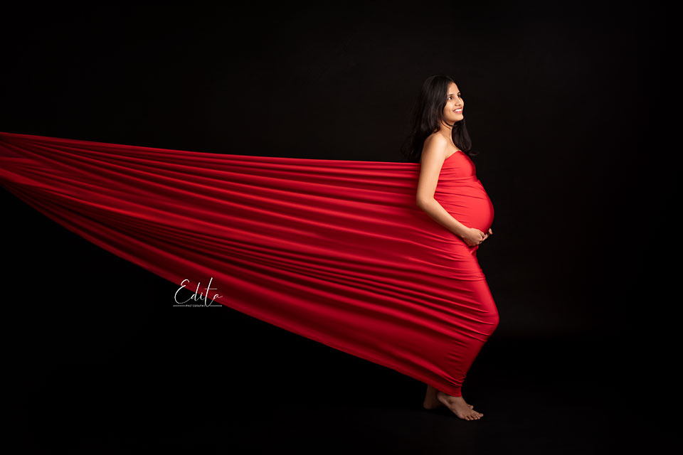 Pregnancy photoshoot in red stretched fabric 