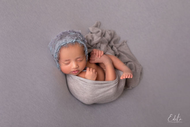 Indian baby in grey posing on beanbag back pose