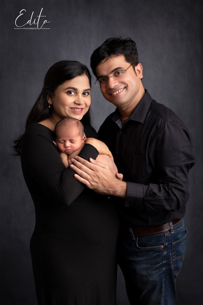 Parents and newborn posing