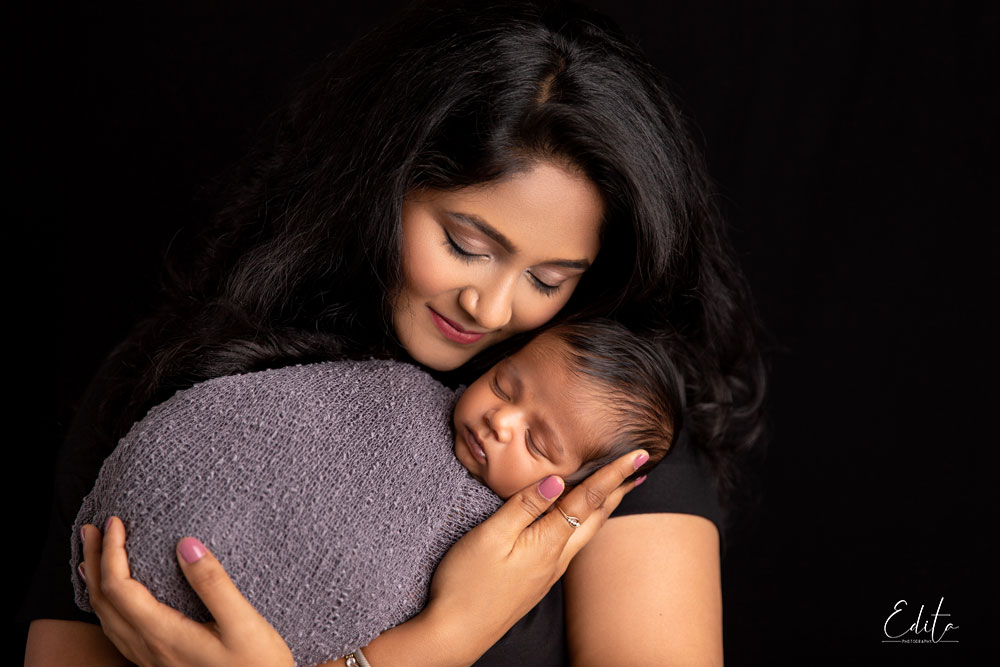 Lovely mom and newborn boy photo on black background. Mothers day