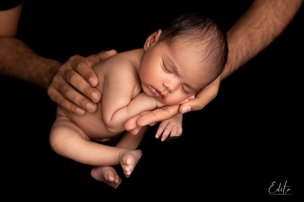Newborn baby in father hands photo in India