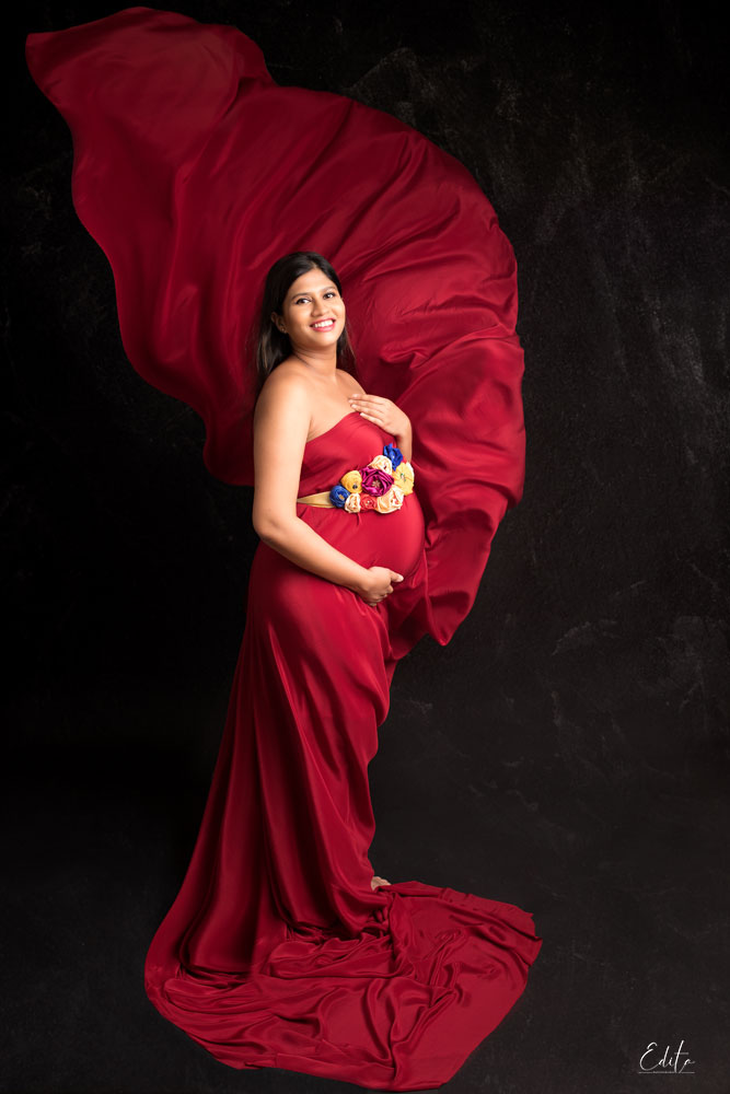 Red fabric tossing in pregnancy photoshoot in Pune