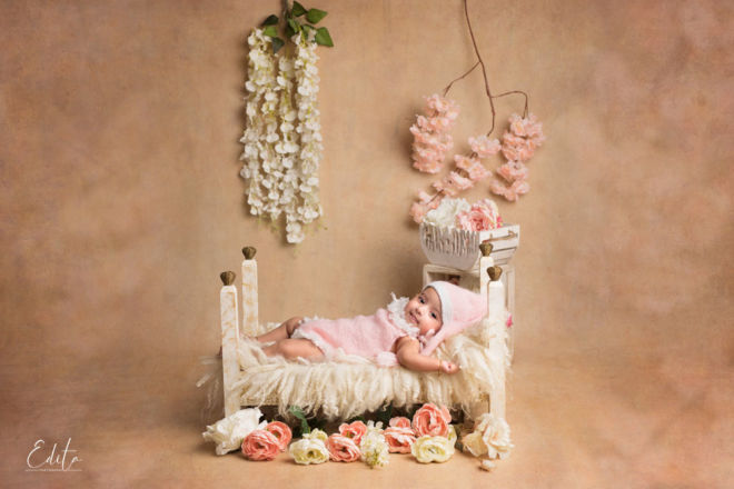 3 month baby girl on tiny bed decorated setup with flowers