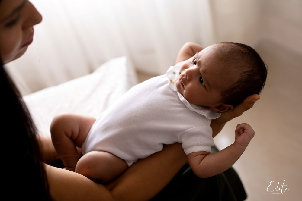 Lifestyle newborn photoshoots. Newborn baby's girl in moms hands backlit pic