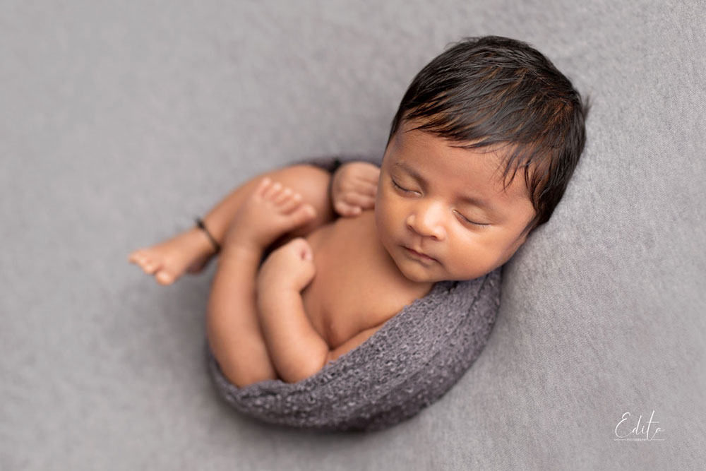 Newborn baby boys in grey wrap on the back an Indian baby
